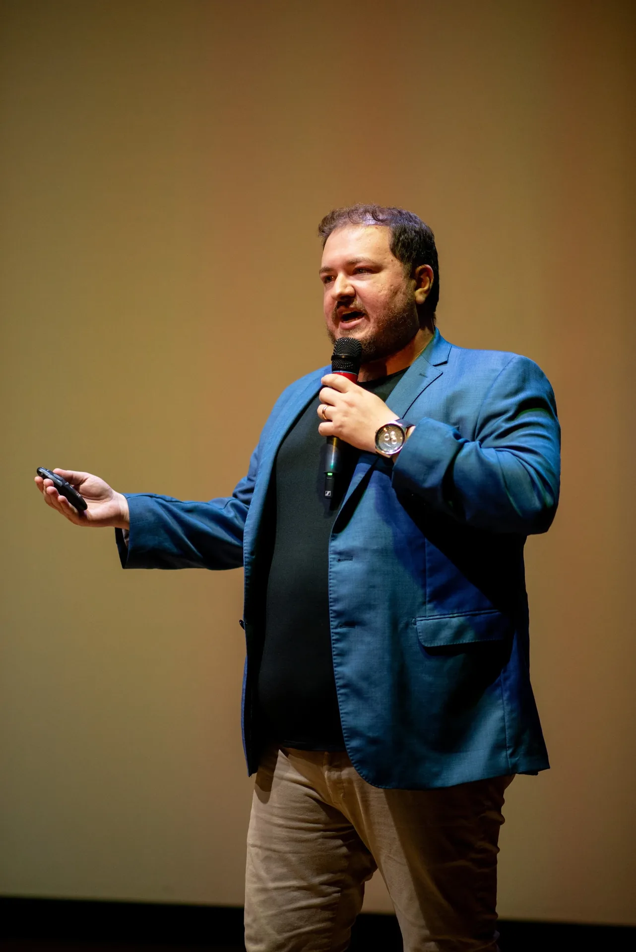 Fernando Maziero falando ao microfone e gesticulando durante uma apresentação.